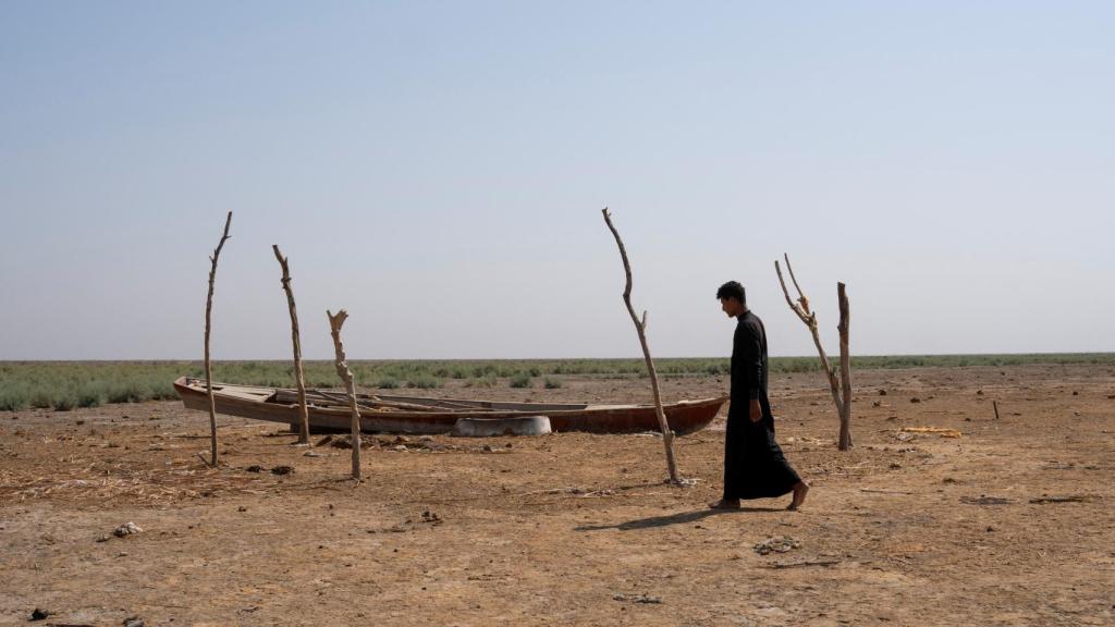 Un hombre camina por las marismas secas de Chebayesh, en Dhi Qarç (Irak).