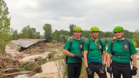 El cabo primero Juan Cebrián y los agentes Juanma Arias y Alfonso Aller, del GREIM de la Guardia Civil, junto a los restos del puente de la Pedrera, en Aldea del Fresno (Madrid).