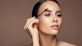 Imagen de archivo de una mujer peinándose las cejas. Foto: iStock.