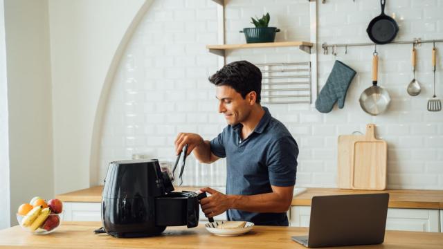 Un hombre cocinando en la freidora de aire. Foto: iStock.