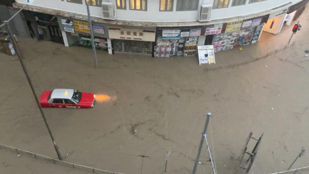 Un taxi hongkonés intenta avanzar en una calle totalmente inundada.