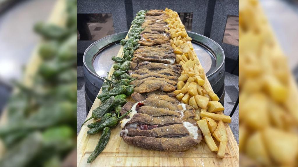 Cachopo con patatas y pimientos en la tabla de 1,11 centímetros.