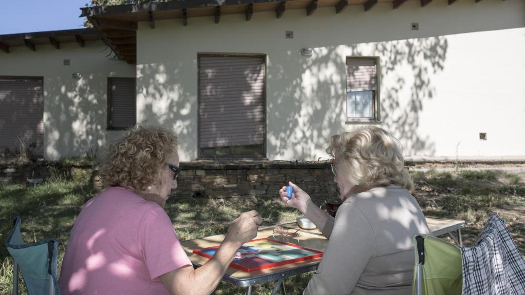 Dos mujeres juegan al parchís en Perlora Ciudad de Vacaciones.