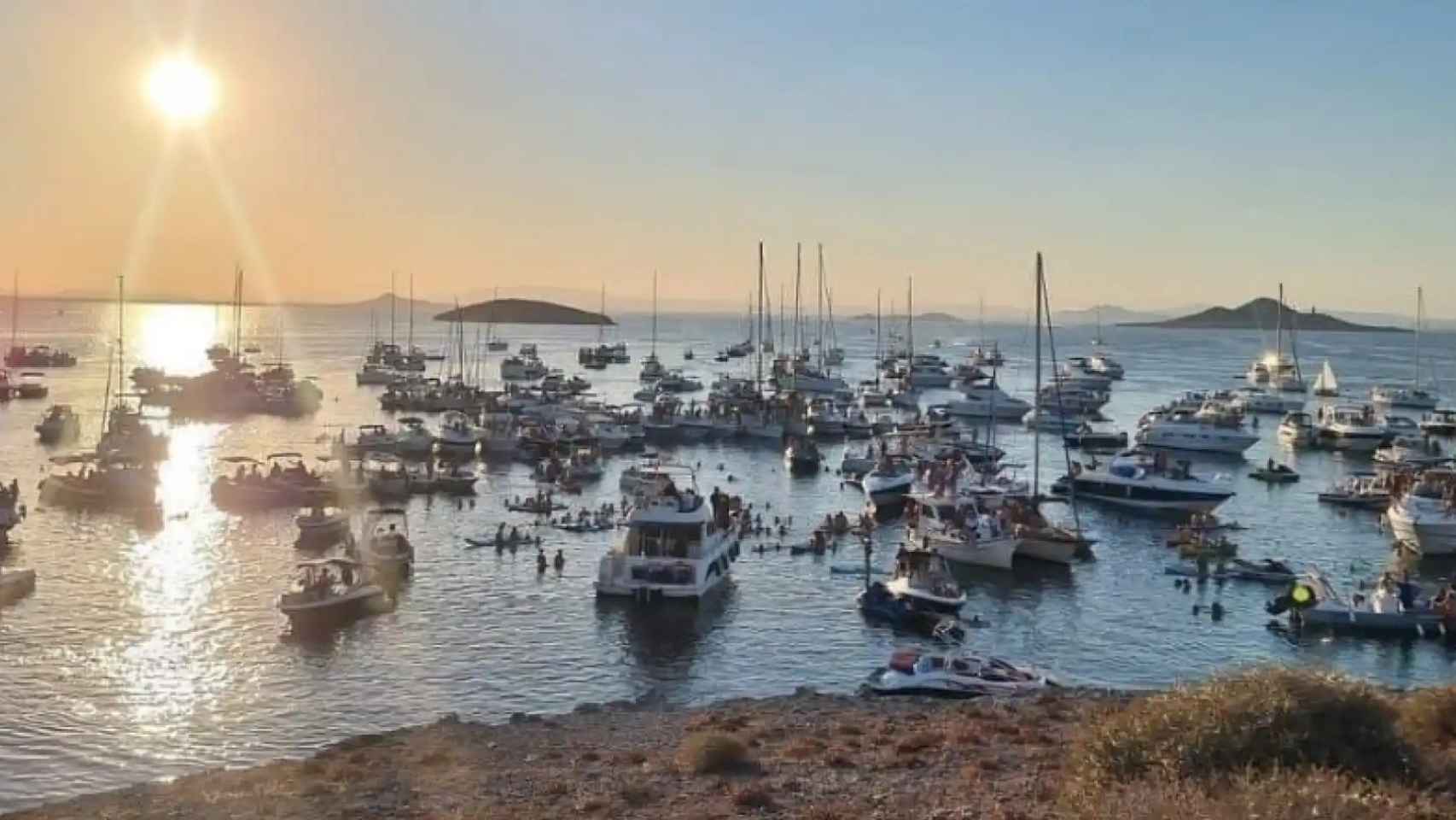 Casi un centenar de barcos de recreo participando en un concierto con macrobotellón, en agosto de 2022, en la isla del Ciervo, un espacio protegido del Mar Menor.