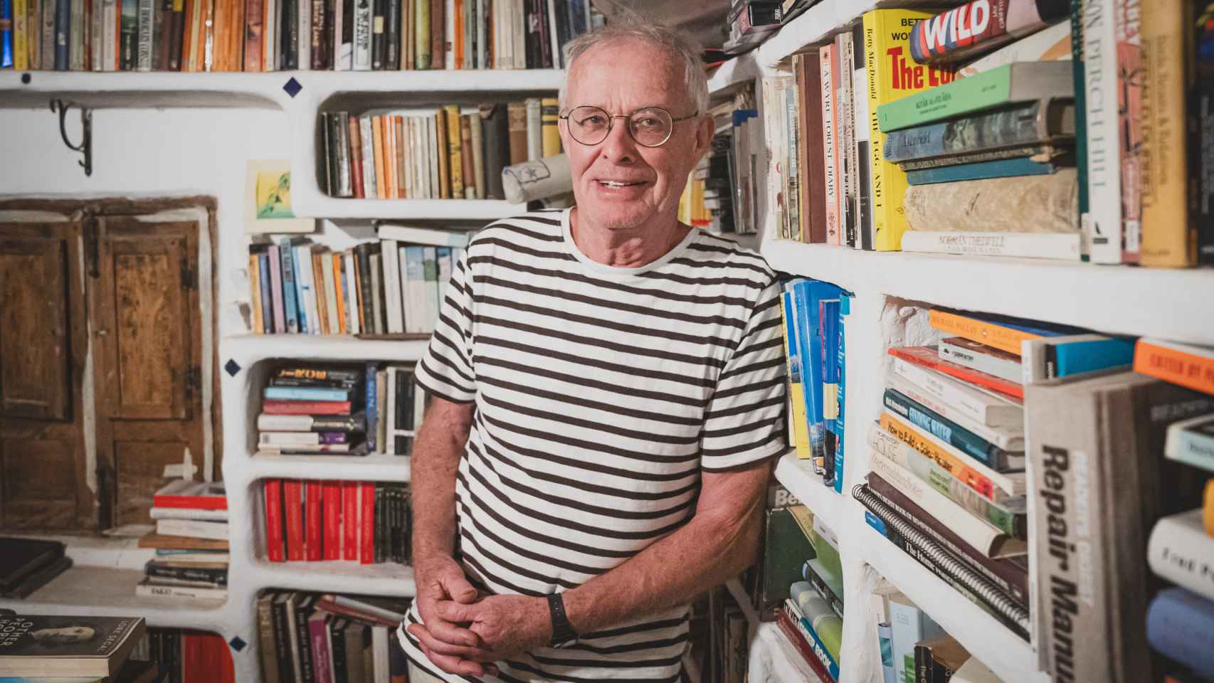 Chris Stewart posa en su biblioteca, compuesta por miles de libros, la mayoría escritos en inglés.
