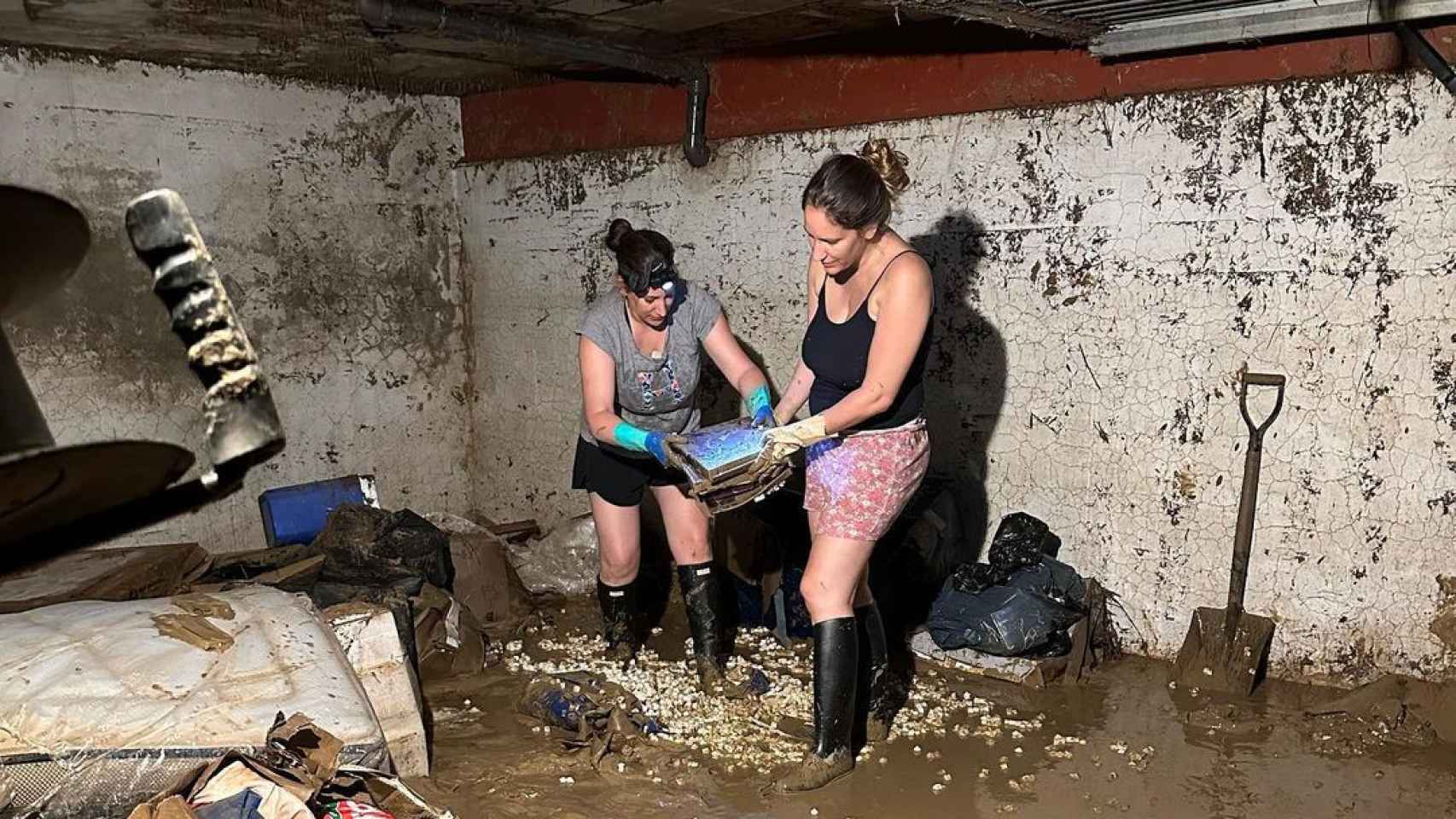 María Toledo (d) y su hermana limpiando una estancia que se inundó por completo.