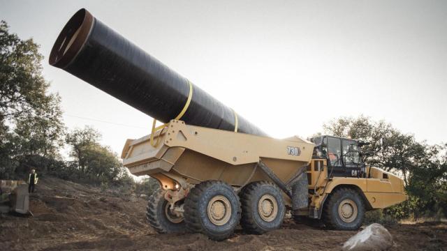 Un camión transporta un tramo de la nueva tubería.