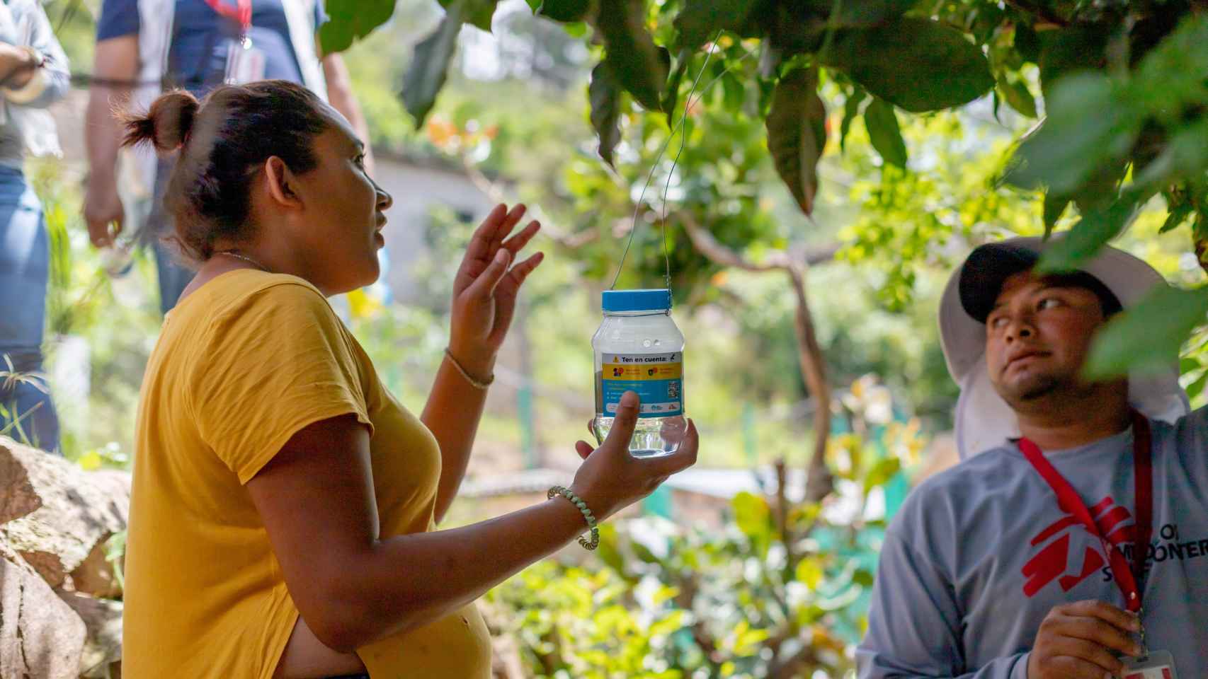 Julia López, una de las voluntarias que ha colocado un tarro con huevos de mosquitos que portan Wolbachia en su casa, explica dónde colocarlo.