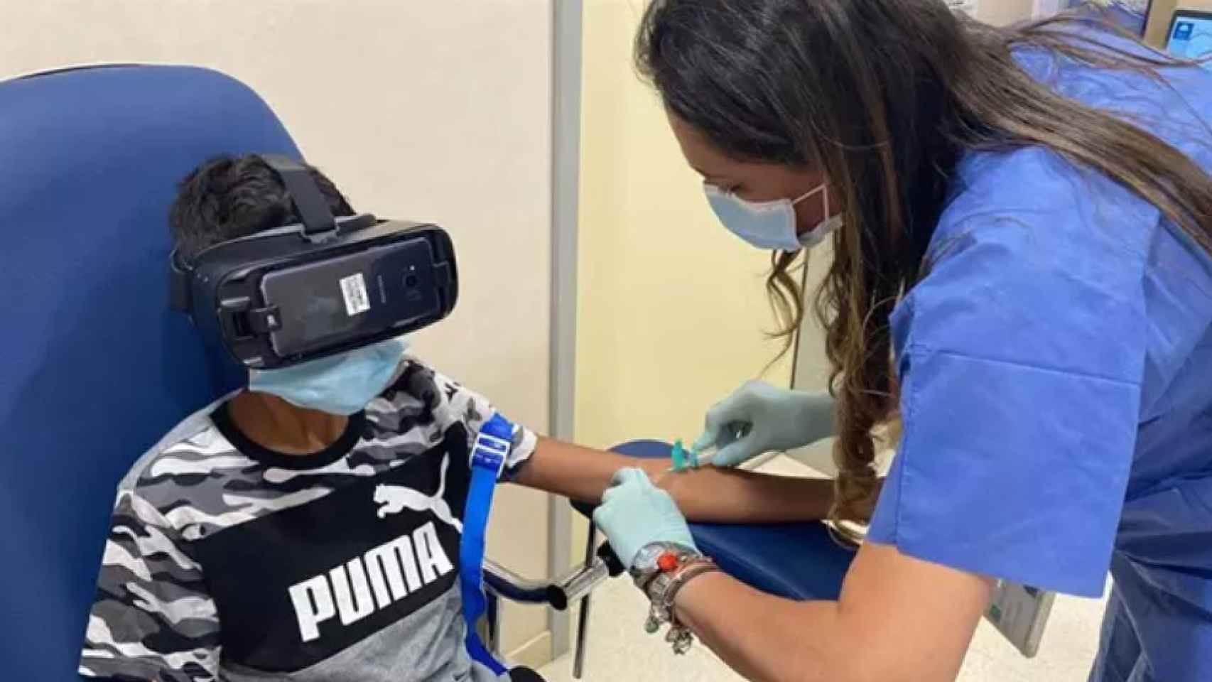 Un niño usa unas gafas de realidad virtual mientras le sacan sangre.