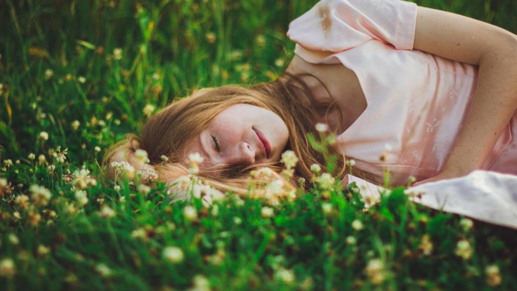 Imagen de archivo de una mujer tumbada sobre plantas. Foto: iStock.