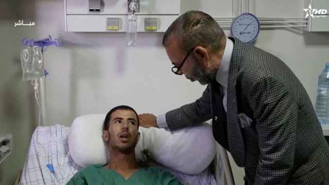 El rey Mohammed VI de Marruecos se reúne con un superviviente del terremoto en un hospital de Marrakech.