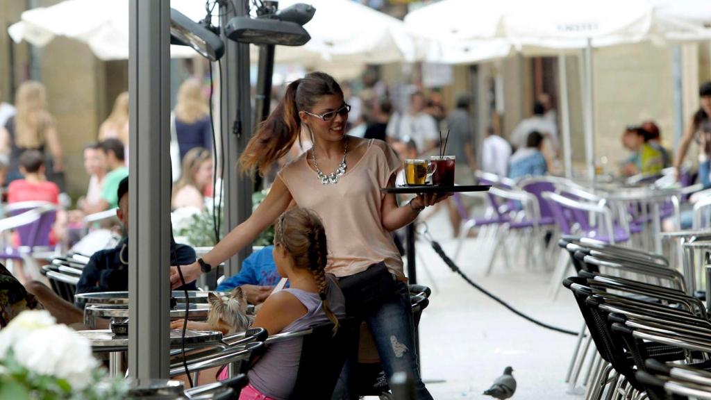 Una camarera sirviendo en una terraza.