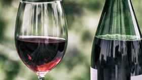 Imagen de archivo de una botella de vino tinto y de una copa.