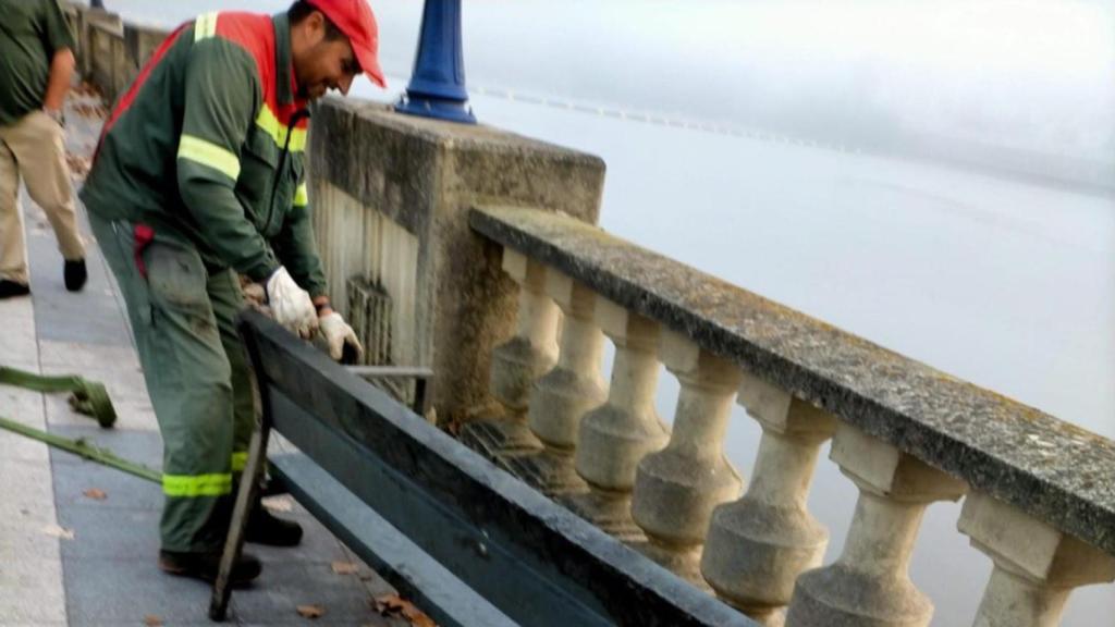 Operarios de Culleredo (A Coruña) retiran un banco que había sido arrojado a la ría de O Burgo