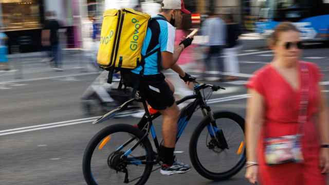 Un repartidor de Glovo en bicicleta por una calle del centro de Madrid.