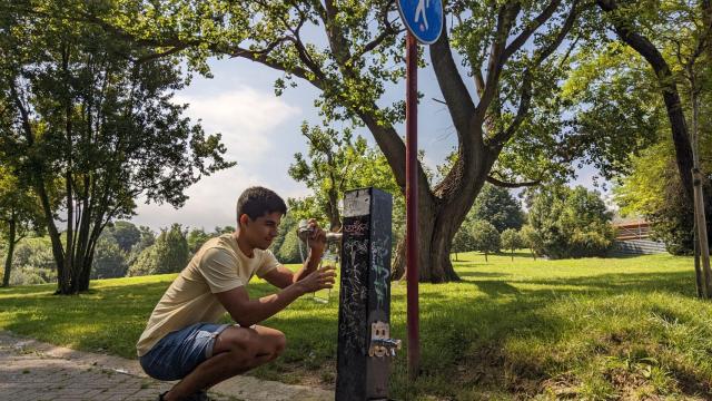 Un usuario de las botellas de Ozeanic lleva agua en una fuente pública.