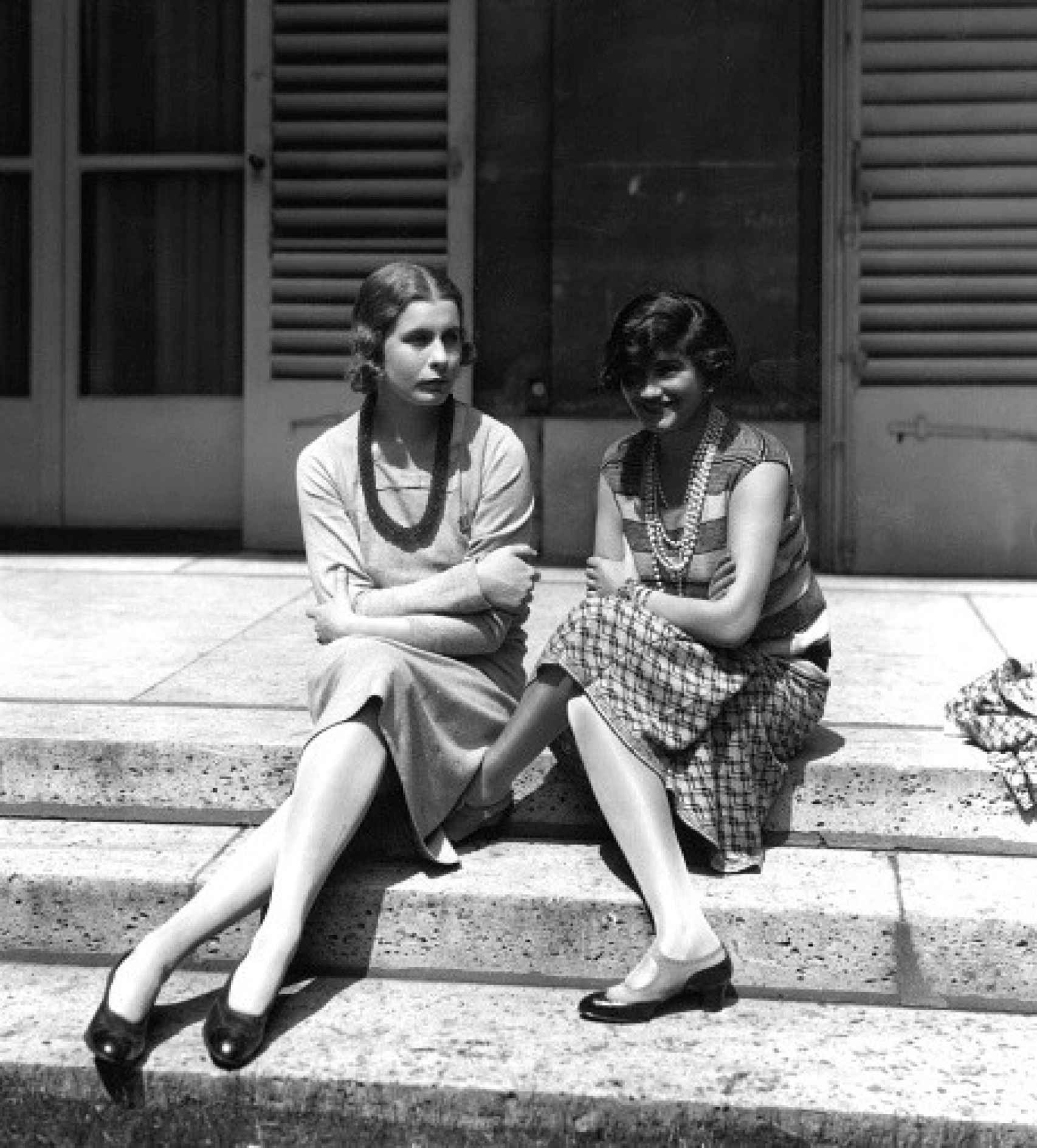 Gabrielle ‘Coco’ Chanel conversa relajadamente con Lady Iya Abdy en las escaleras de una casa de verano, y la diseñadora luce zapatos mary jane.