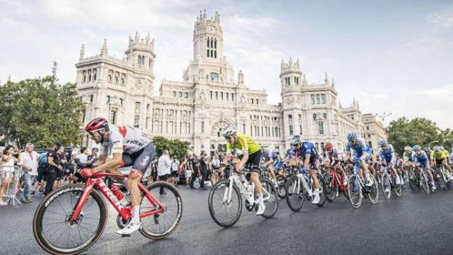 Ciclistas de la Vuelta rodando frente al Palacio de Cibeles.