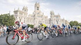 Ciclistas de la Vuelta rodando frente al Palacio de Cibeles.