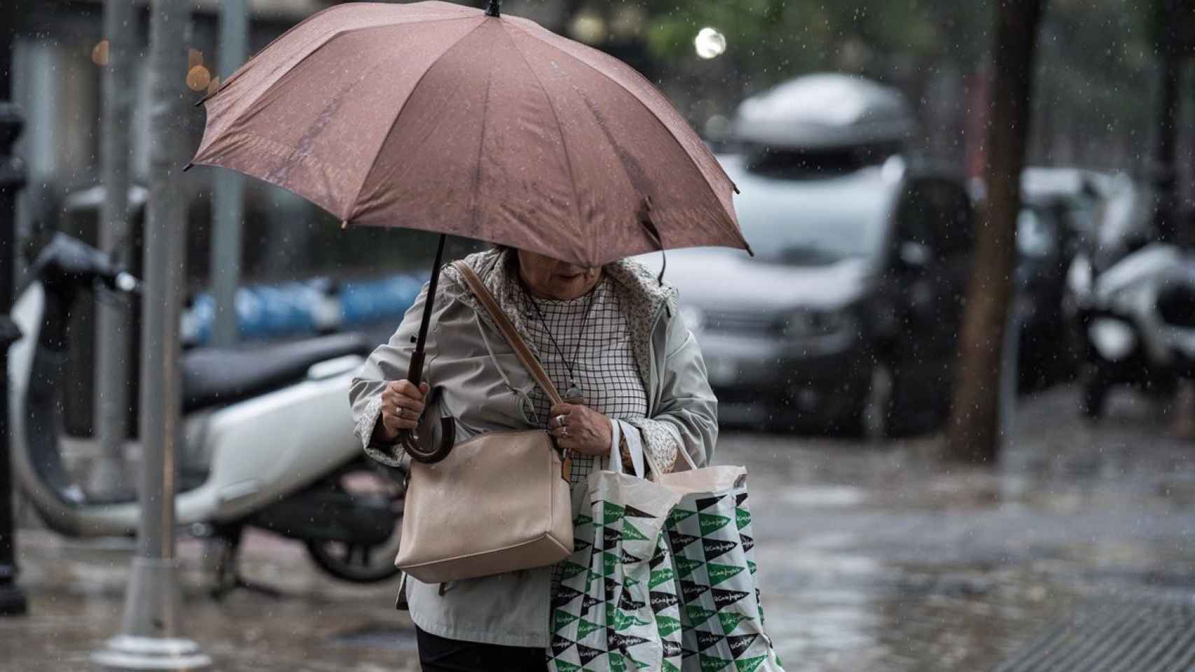 Una mujer pasea con un paraguas en una imagen de archivo.