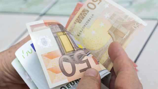 Un jubilado cuenta billetes de euro.