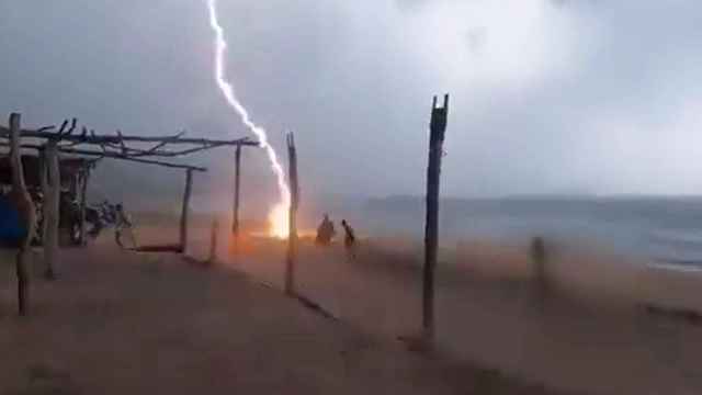 El momento en el que un rayo alcanza a una persona en la playa de Michoacán, México.