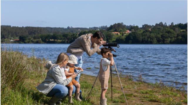 Una familia observa aves en el embalse de Cecebre