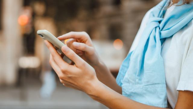 Una mujer mira su teléfono móvil.