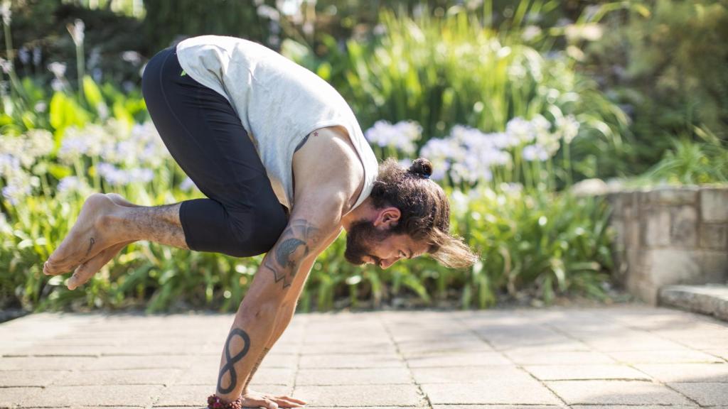 Imagen de archivo de un hombre practicando yoga en el exterior.