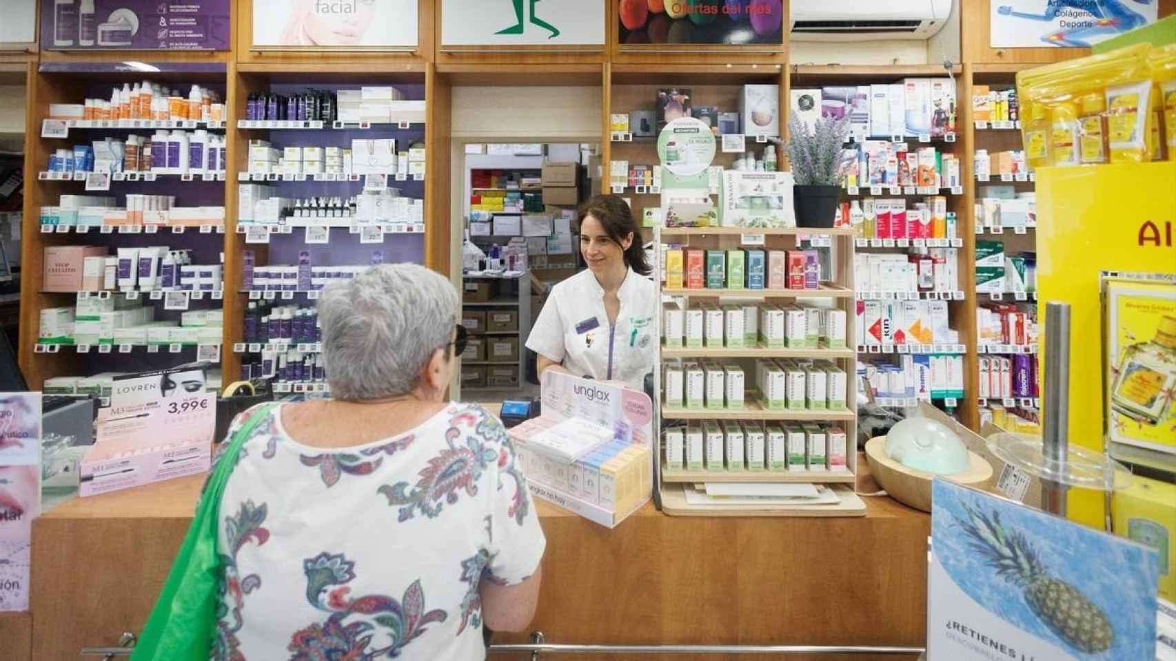 Imagen de archivo de una jubilada comprando en una farmacia.