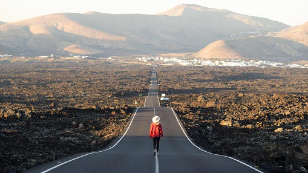 Imagen de un hombre caminando solo por la carretera.