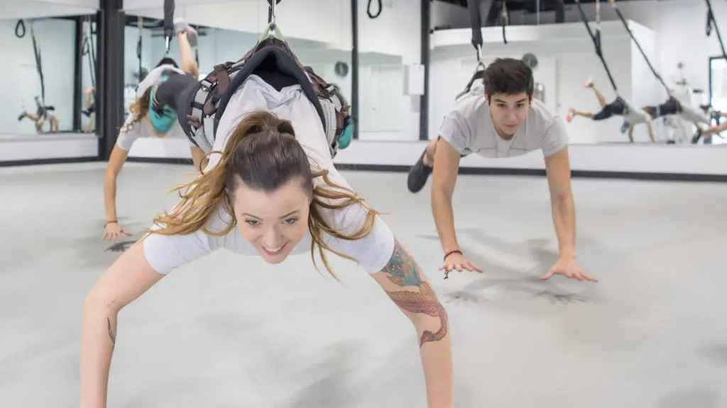 Una pareja en el gimnasio realizando 'Bungee Fitness'.