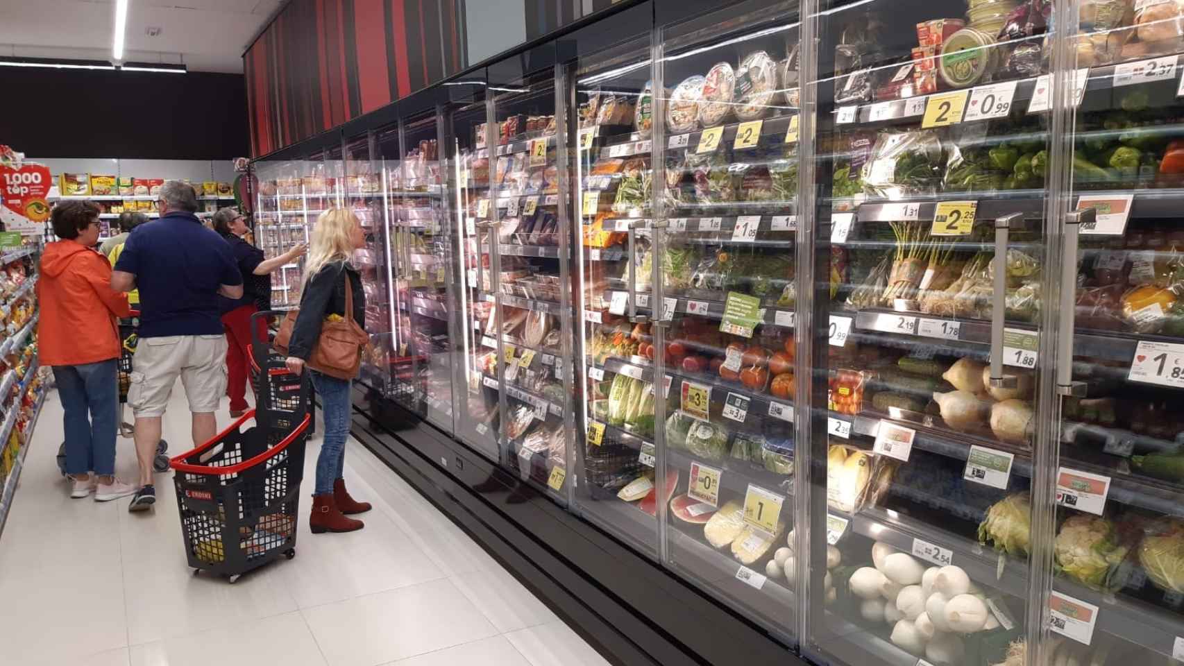 Varios clientes haciendo sus compras en un supermercado.