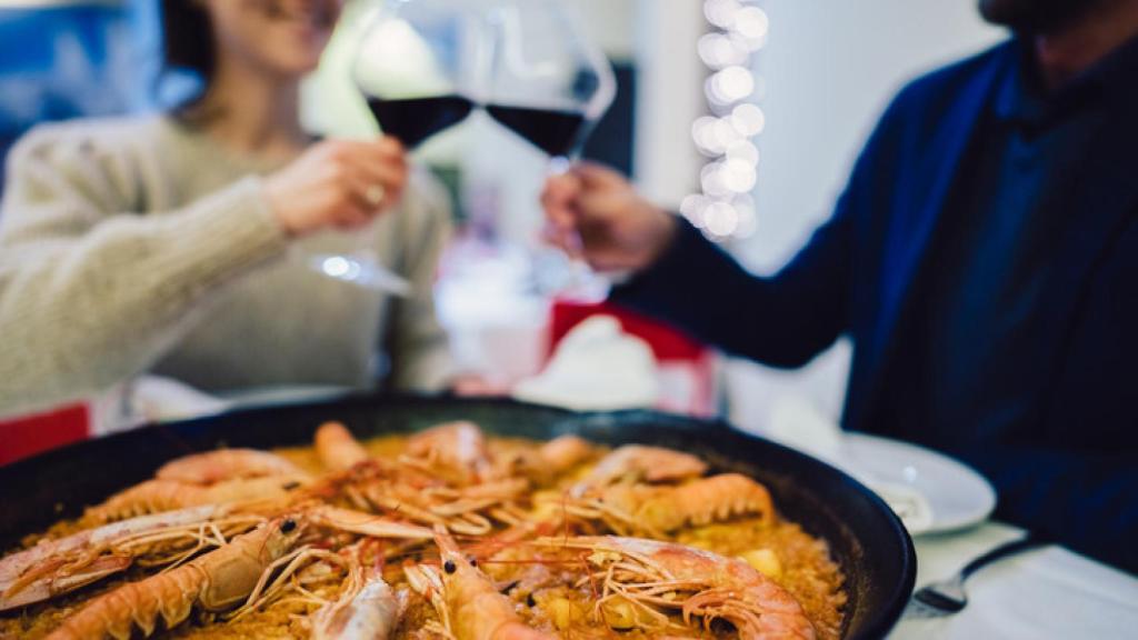 Una pareja disfrutando de una paella.