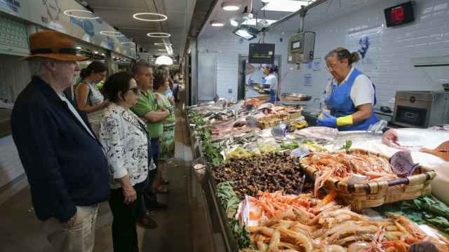 Varias personas compran alimentos en un mercado