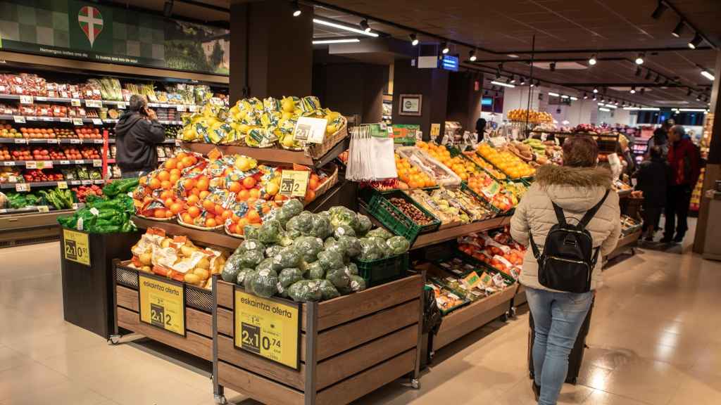 Varios consumidores comprando en un supermercado.