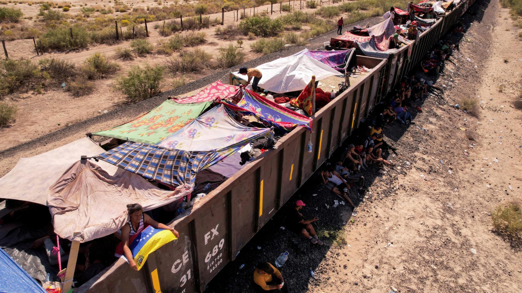 Migrantes con tiendas de campaña sobre el tren parado en Villa Ahumada
