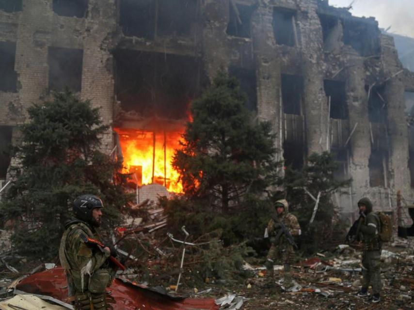 Tropas rusas ante un edificio destruido de Azovstal, en abril de 2022, en Mariúpol.