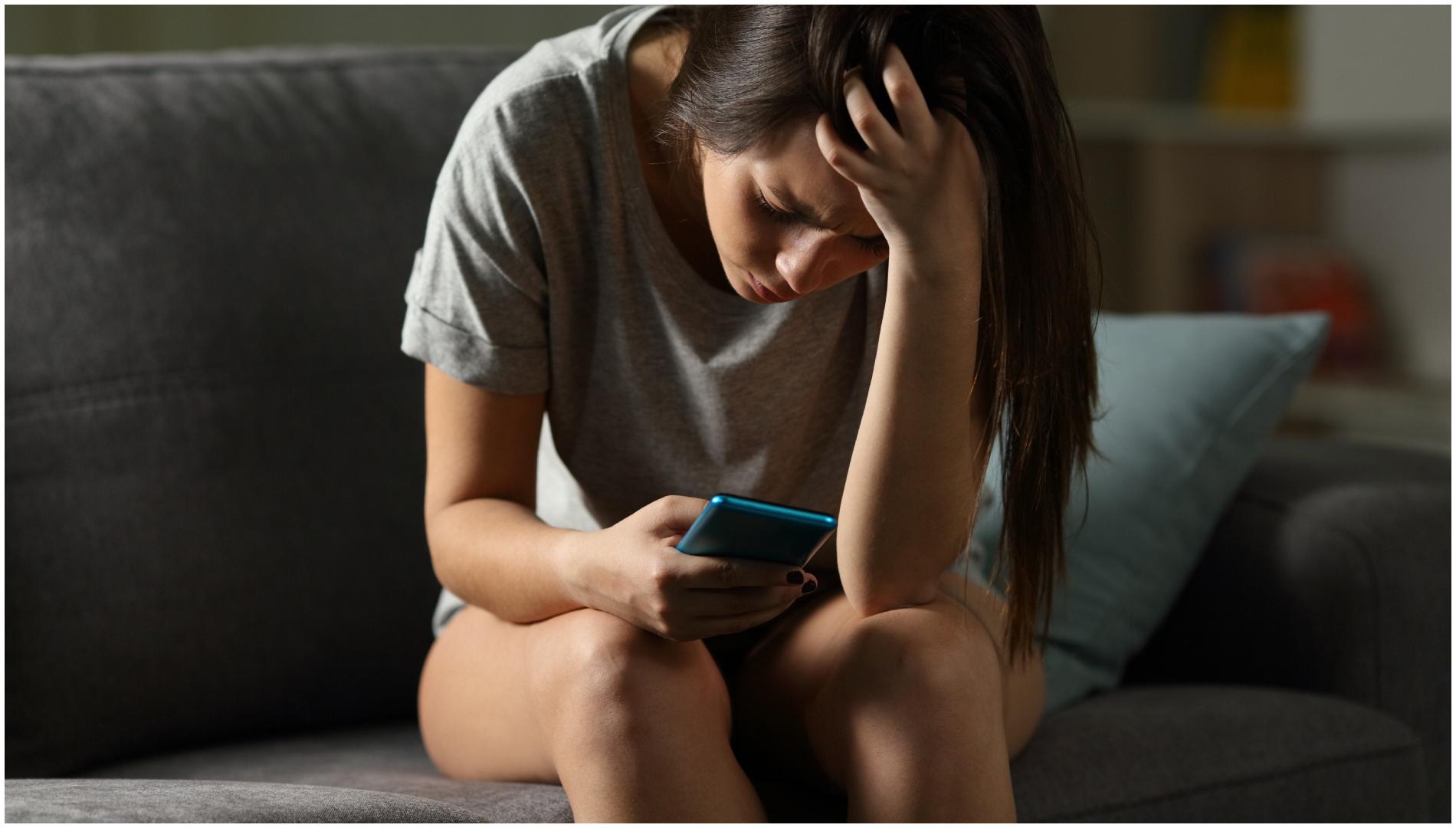 Una joven consulta el móvil preocupada (Shutterstock)
