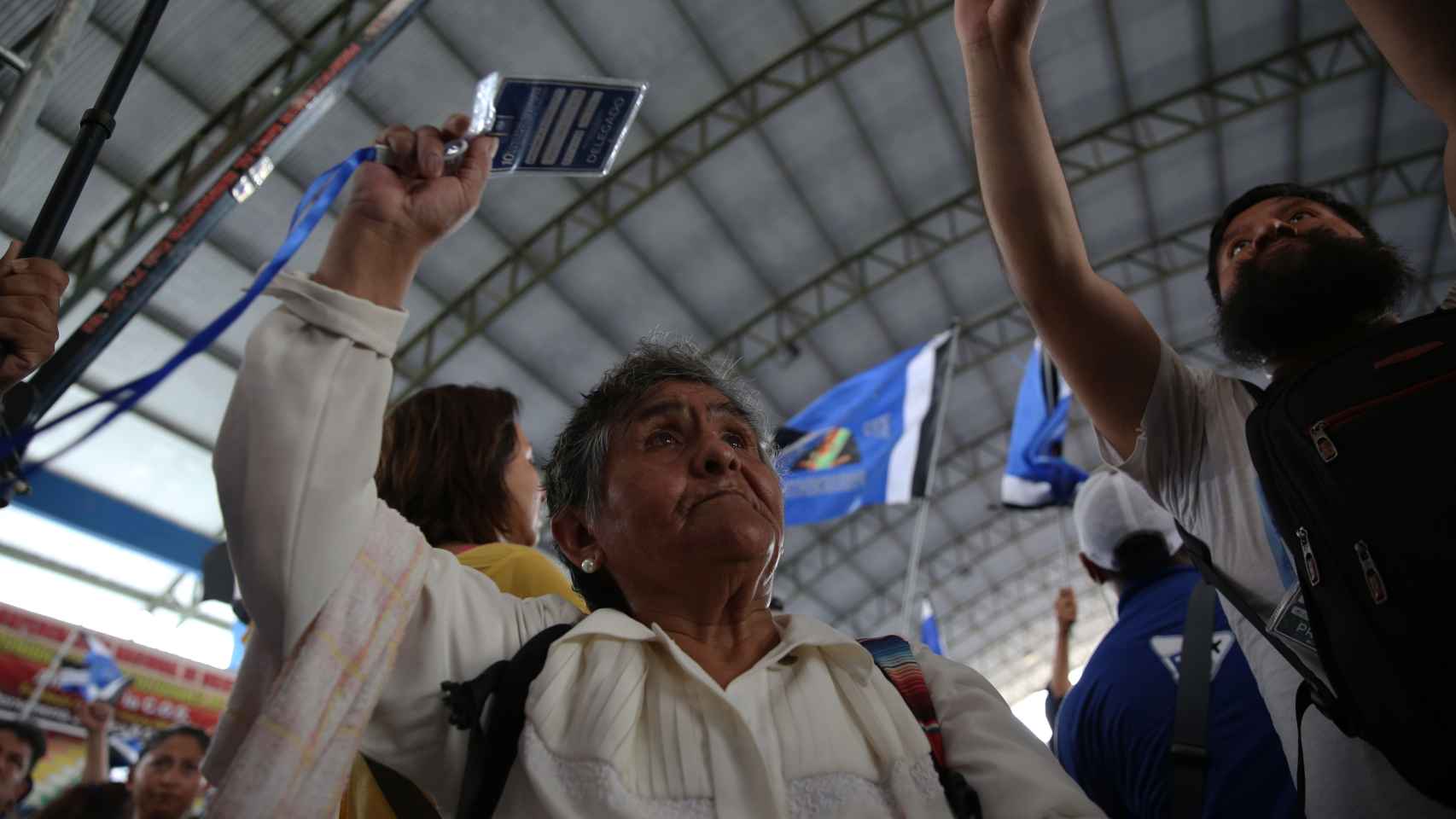 Una representante social levanta sus acreditaciones en apoyo del expresidente Evo Morales.