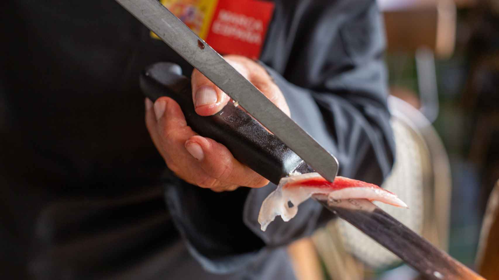El maestro jamonero desliza una loncha de jamón ibérico por la hoja de su cuchillo.
