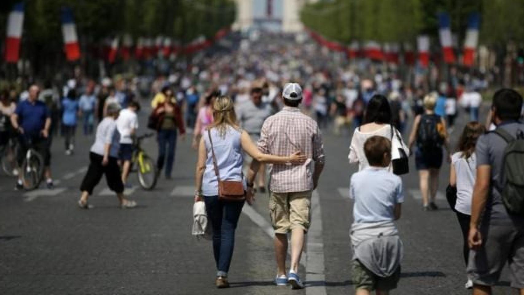 Peatones pasean por la Avenida de los Campos Elíseos de París.