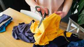 Imagen de archivo de una persona cortando el tejido de una prenda.