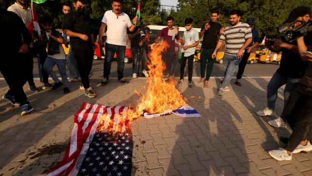 Ciudadanos iraquíes queman la bandera de Israel y EEUU en Bagdad.