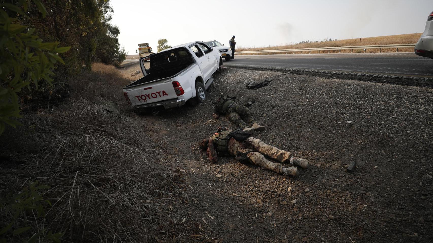 El cuerpo de un militante de Hamás yace al lado de una carretera del sur de Israel, cerca de la frontera con Gaza