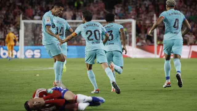 Los jugadores del Barcelona celebran el segundo gol con Callejón en el suelo.
