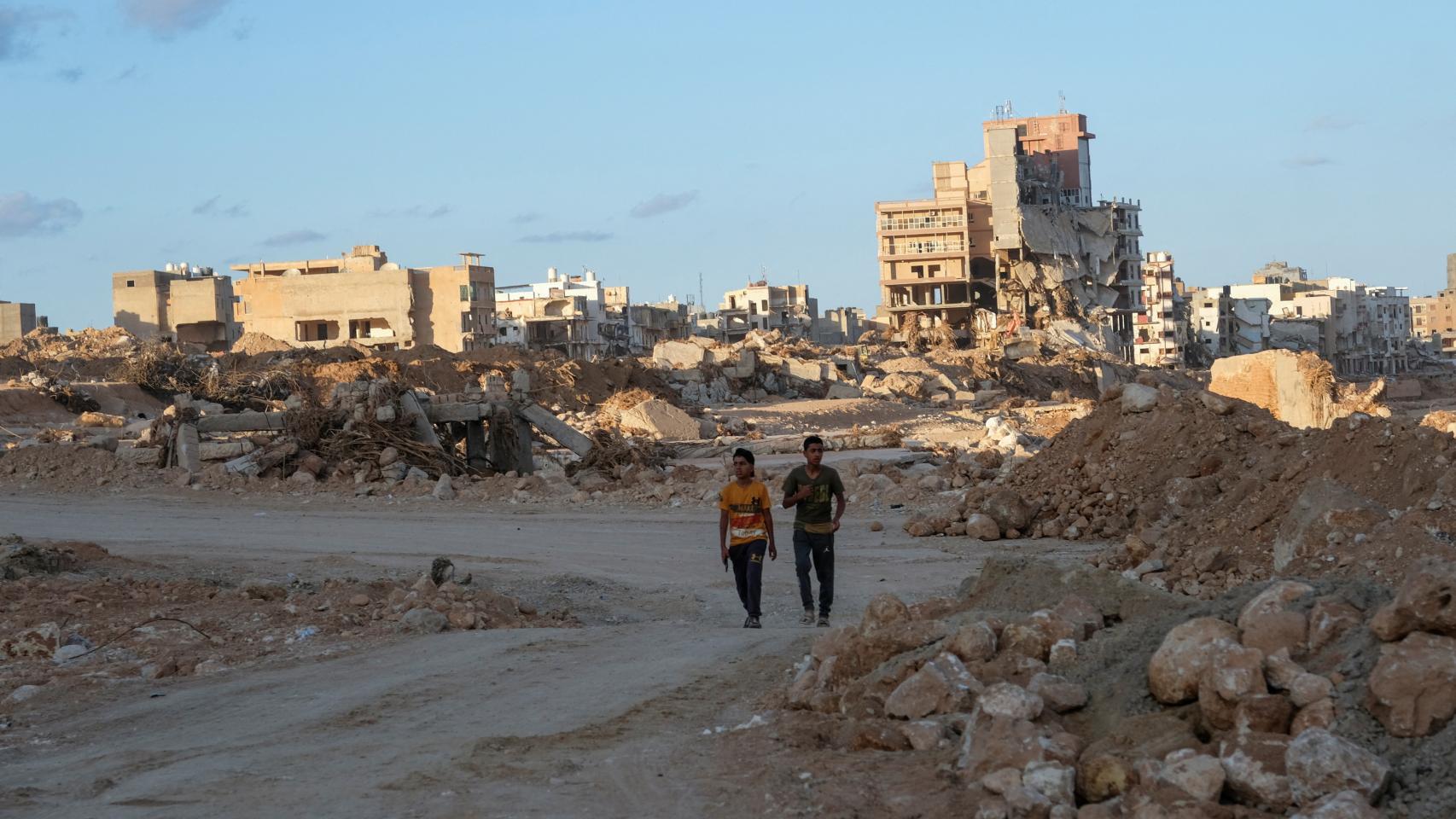 Unos chicos caminan por una calle afectada por las inundaciones en Derna, Libia, 28 de septiembre de 2023.