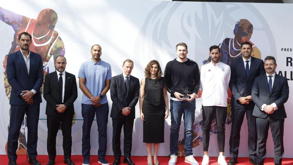 a presidenta de la Comunidad, Isabel Díaz Ayuso (C), junto a varios jugadores del Real Madrid; al escolta de los Dallas Mavericks Luca Doncic (4d) y al director de Relaciones Institucionales del Real Madrid, Emilio Butragueño (4i).