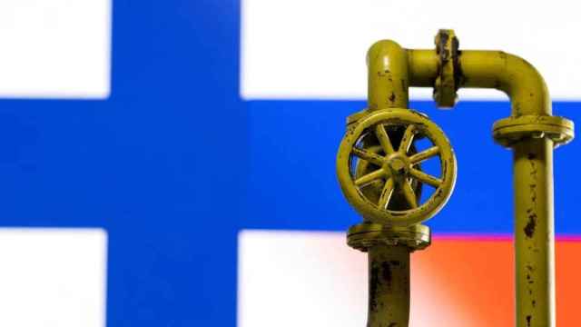 La llave de un gasoducto delante de una bandera de Finlandia.