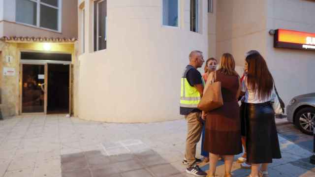 La Policía Científica habla con concejales de Málaga este martes, junto a la entrada del edificio donde han sido encontrados los cadáveres,